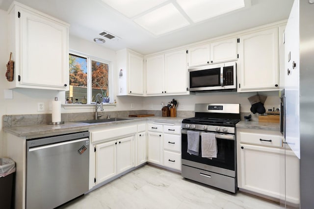 kitchen with white cabinetry, appliances with stainless steel finishes, and sink