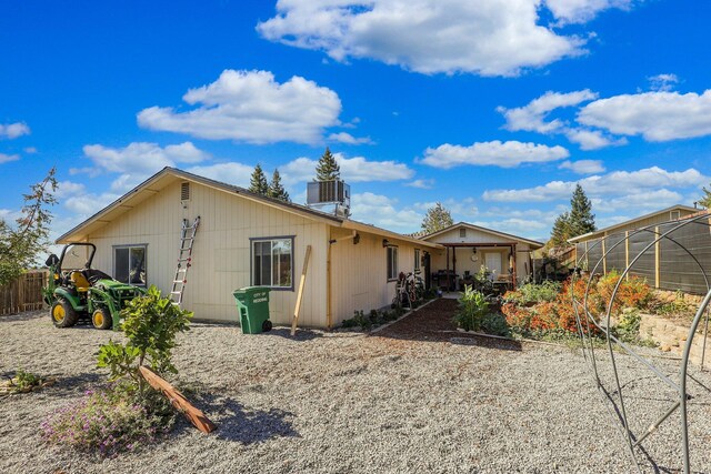 rear view of property featuring a garage and central AC