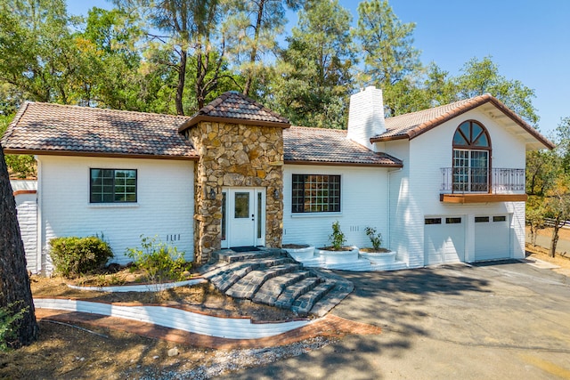 mediterranean / spanish-style home with a balcony and a garage