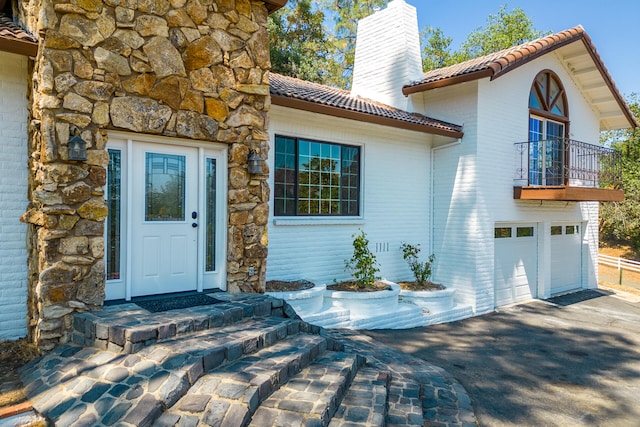 entrance to property featuring a balcony and a garage