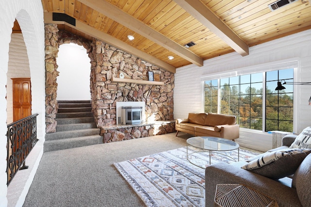 carpeted living room featuring lofted ceiling with beams, a stone fireplace, and wood ceiling