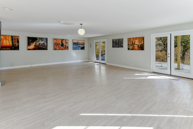 spare room with french doors and light wood-type flooring