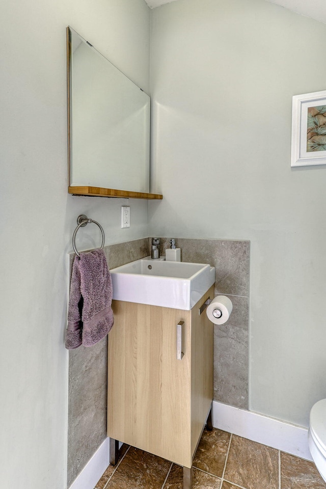 bathroom with toilet, vanity, and tile patterned flooring