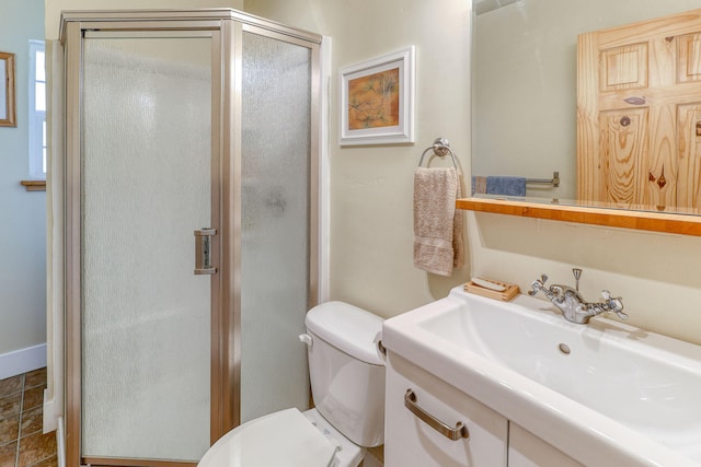 bathroom featuring toilet, an enclosed shower, and vanity