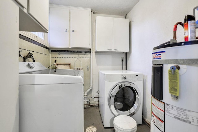 laundry room with a textured ceiling, cabinets, washer and clothes dryer, and gas water heater