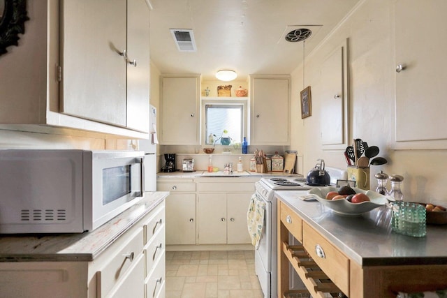 kitchen with white appliances, sink, and hanging light fixtures