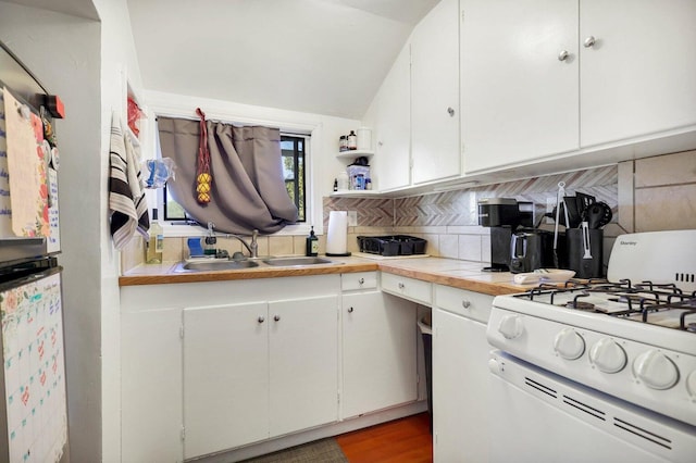 kitchen with white gas stove, sink, backsplash, white cabinets, and hardwood / wood-style flooring