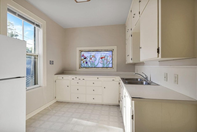 kitchen with white cabinets, white fridge, and sink