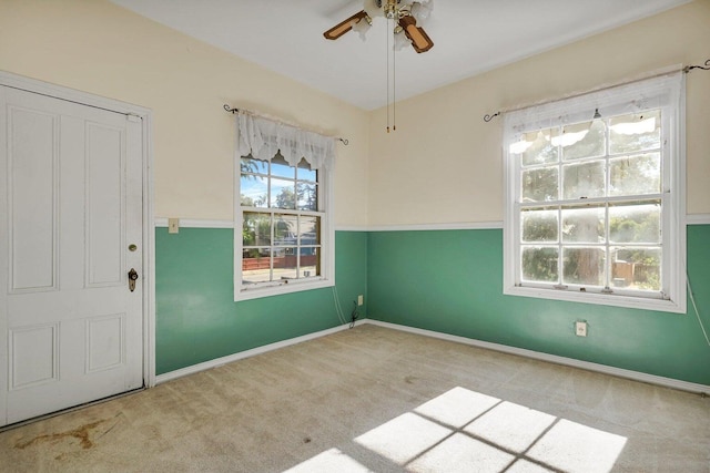 interior space with light colored carpet, a healthy amount of sunlight, and ceiling fan