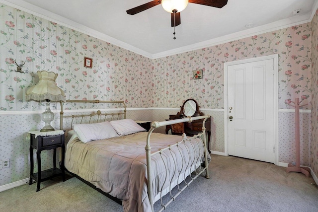 carpeted bedroom featuring crown molding and ceiling fan