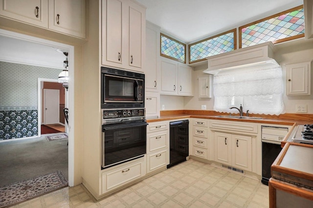 kitchen featuring light colored carpet, black appliances, and sink