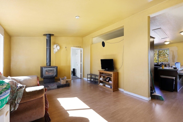 living room with wood-type flooring and a wood stove