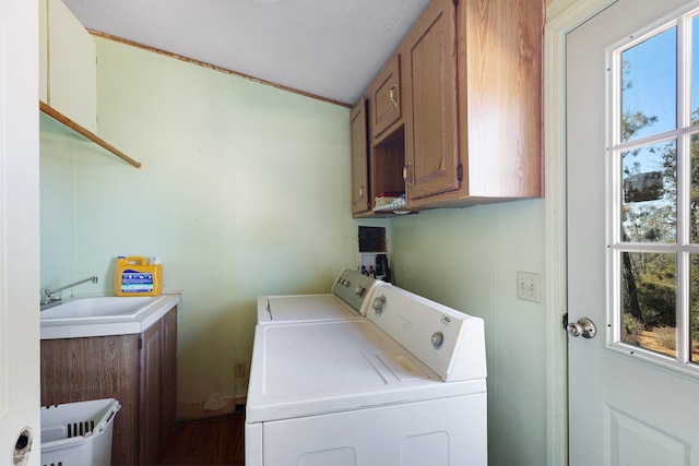 washroom with sink, independent washer and dryer, a textured ceiling, and cabinets