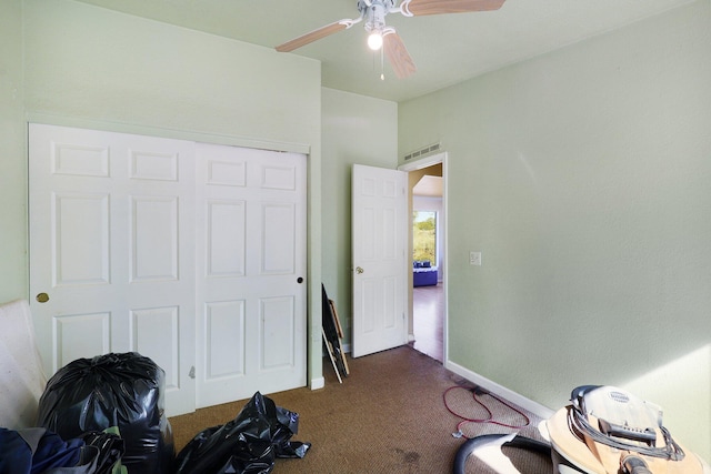 interior space featuring ceiling fan and dark colored carpet