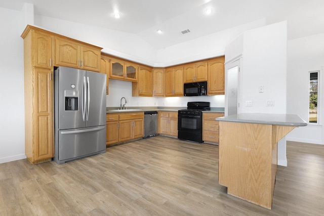 kitchen with lofted ceiling, sink, light hardwood / wood-style flooring, kitchen peninsula, and black appliances