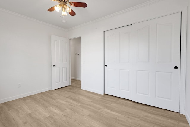 unfurnished bedroom featuring ornamental molding, ceiling fan, light hardwood / wood-style floors, and a closet