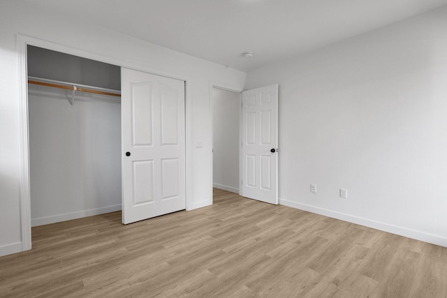 unfurnished bedroom with a closet and light hardwood / wood-style flooring