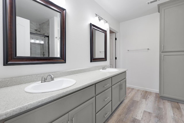 bathroom with wood-type flooring, vanity, and walk in shower