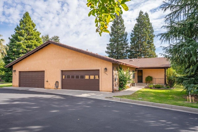 ranch-style home with a garage and a front lawn