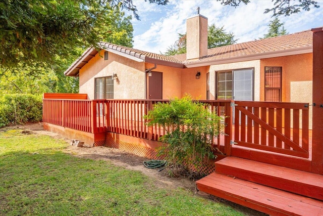 rear view of property featuring a wooden deck and a yard