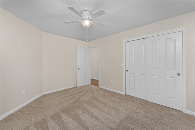 unfurnished bedroom featuring a closet, ceiling fan, and light carpet