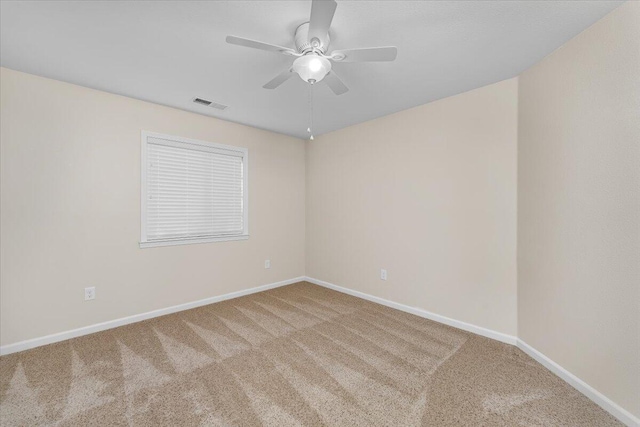 carpeted spare room featuring ceiling fan