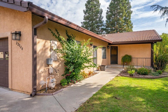 doorway to property featuring a yard and a garage