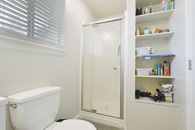 bathroom featuring toilet and walk in shower