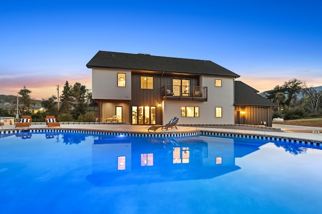 pool at dusk featuring a patio area