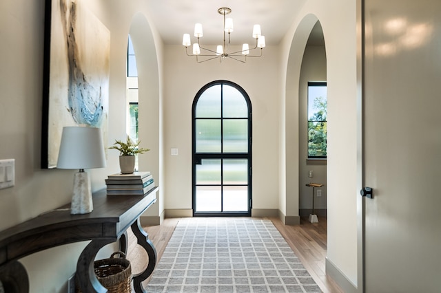 entrance foyer with light hardwood / wood-style flooring and an inviting chandelier