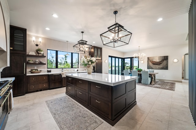 kitchen with sink, a kitchen island, dark brown cabinetry, and decorative light fixtures