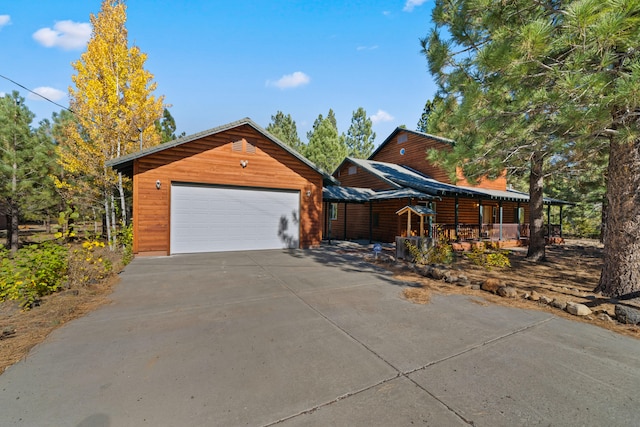 view of front facade with a garage, covered porch, and an outdoor structure