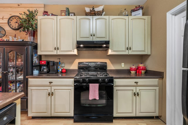 kitchen featuring cream cabinetry, light wood-type flooring, black gas range oven, and range hood