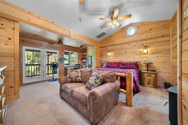 carpeted bedroom with access to exterior, wooden walls, french doors, and ceiling fan