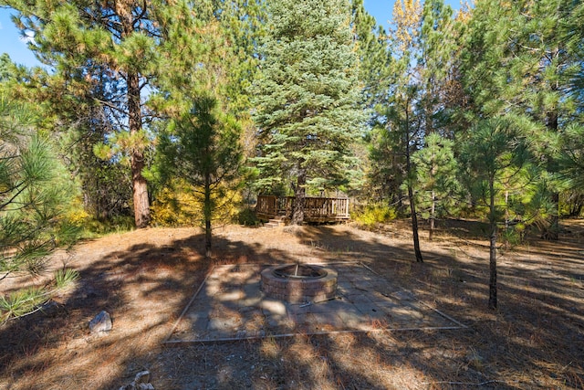 view of yard featuring a wooden deck and a fire pit