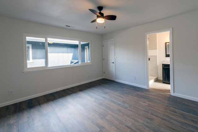 empty room with dark wood-type flooring, a textured ceiling, and ceiling fan