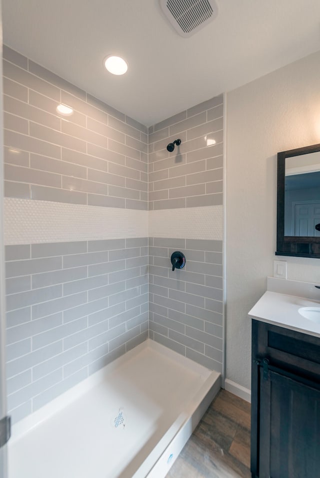 bathroom featuring vanity and tiled shower