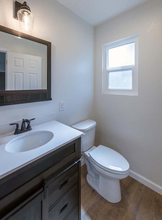 bathroom featuring vanity, wood-type flooring, and toilet