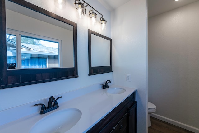 bathroom featuring vanity, toilet, and hardwood / wood-style flooring