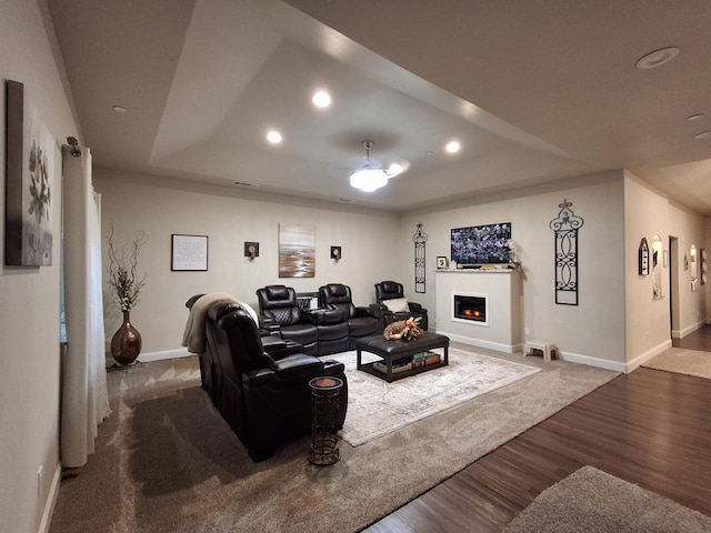 living room featuring an inviting chandelier, dark hardwood / wood-style floors, and a raised ceiling