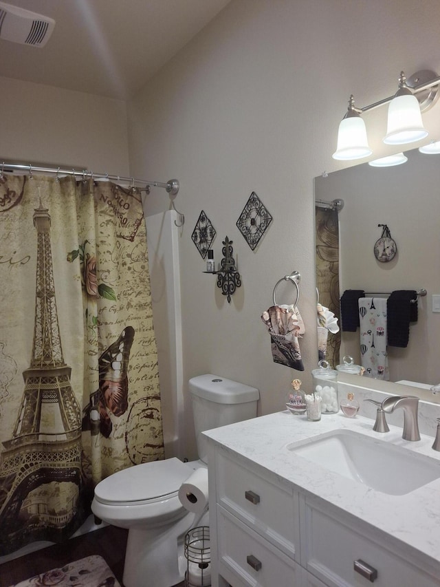 bathroom featuring vanity, a shower with shower curtain, and toilet