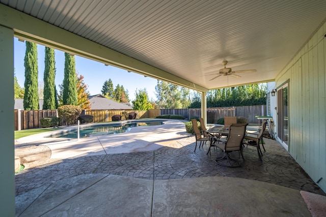 view of patio with a fenced in pool, outdoor dining space, a fenced backyard, and ceiling fan