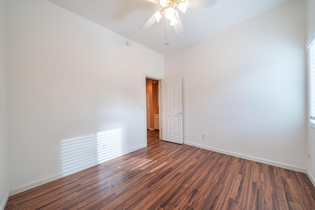 spare room featuring ceiling fan, baseboards, and dark wood-style flooring