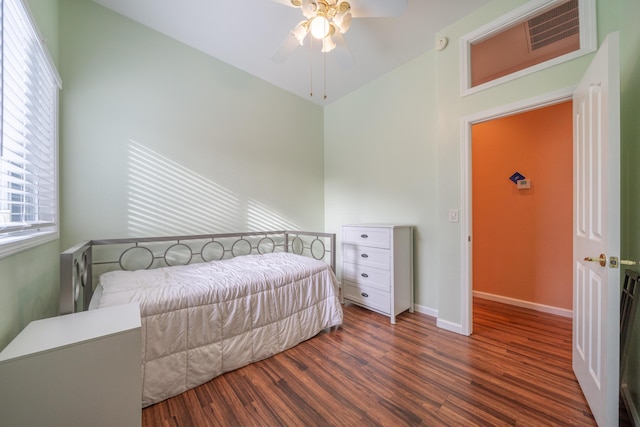 bedroom featuring a ceiling fan, visible vents, baseboards, and wood finished floors