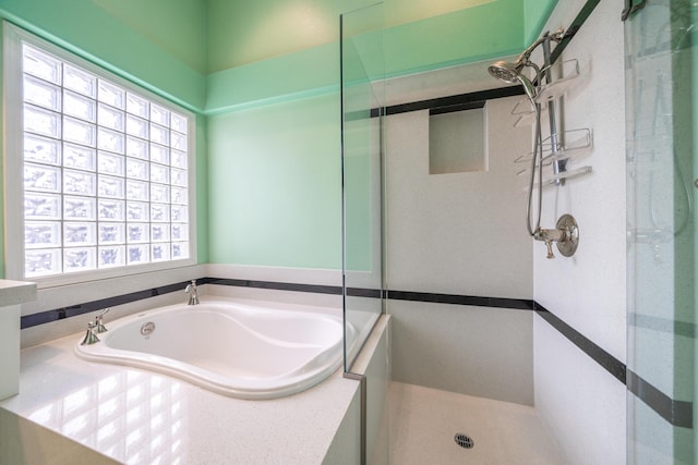 full bathroom with a garden tub and a tile shower