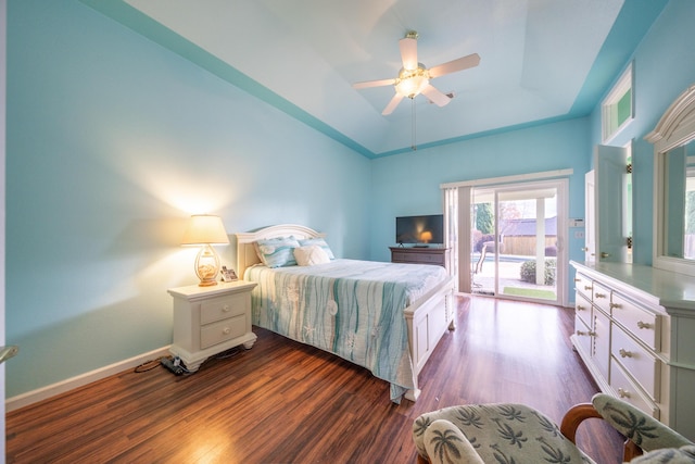 bedroom with dark wood-style flooring, a ceiling fan, baseboards, access to outside, and a tray ceiling