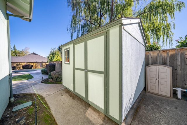 view of shed with a fenced in pool and a fenced backyard