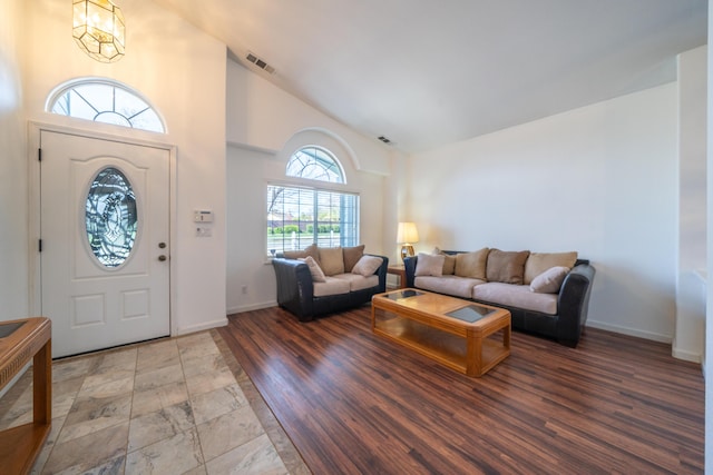 entrance foyer featuring high vaulted ceiling, wood finished floors, visible vents, and baseboards