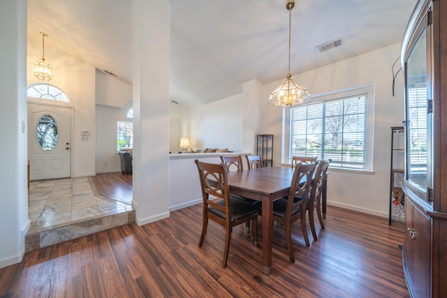 dining space with a chandelier, a wealth of natural light, wood finished floors, and visible vents