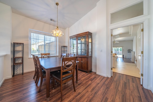 dining area featuring baseboards, a notable chandelier, visible vents, and dark wood-style flooring